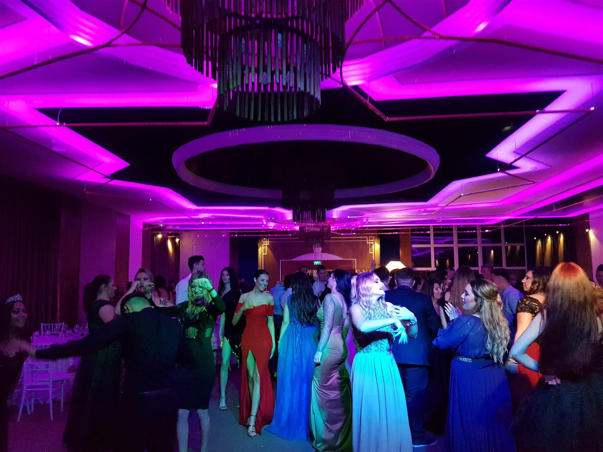 Invitați dansând sub lumini colorate la eveniment