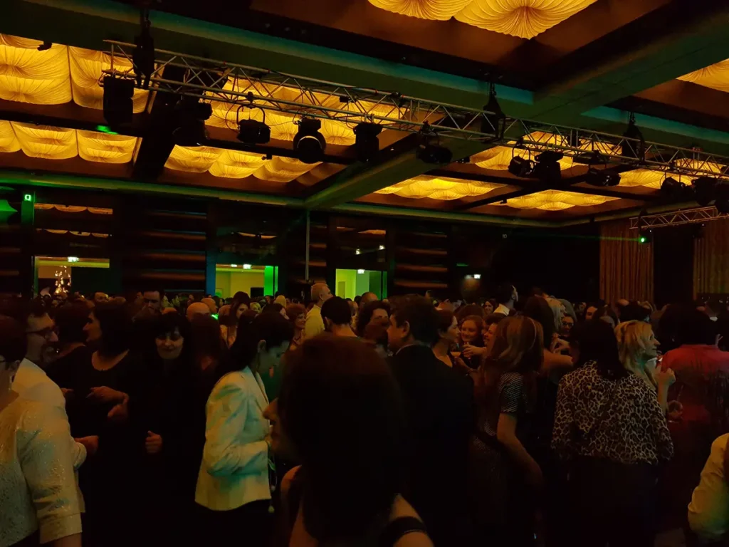 Mulțime la un eveniment corporate, sub lumini aurii