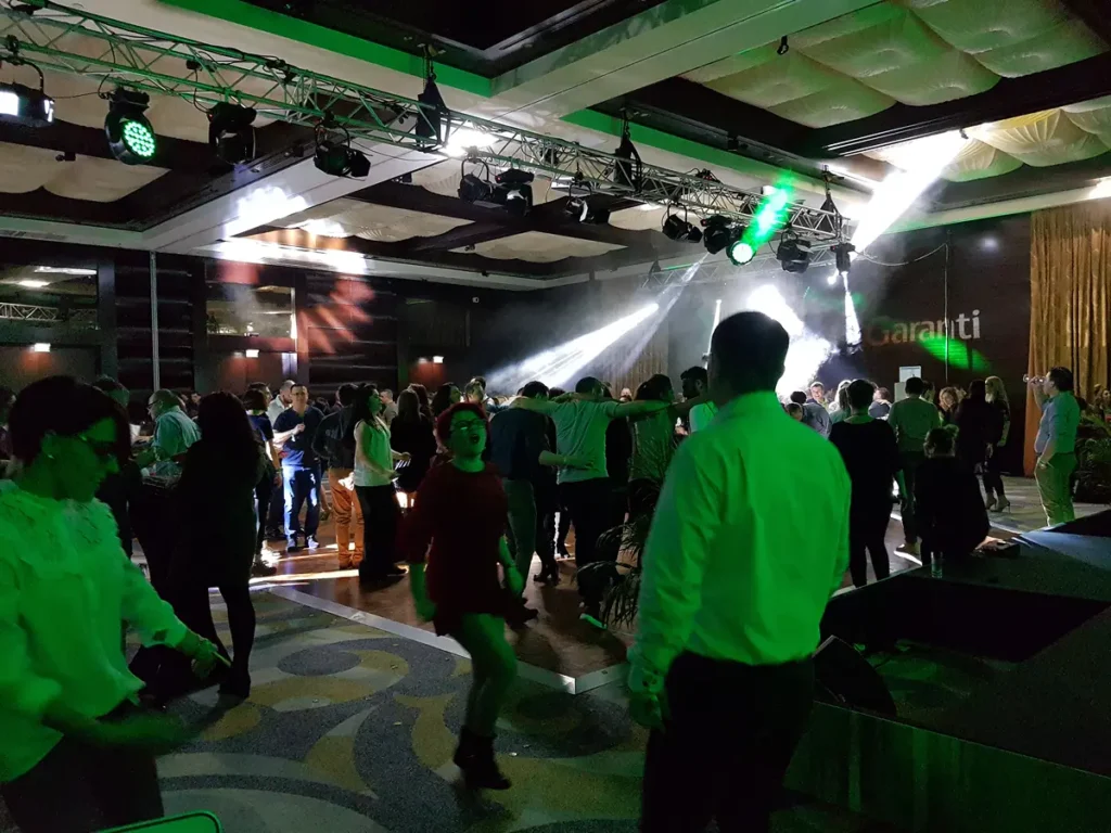 Invitați dansând sub lumini verzi la un eveniment corporate