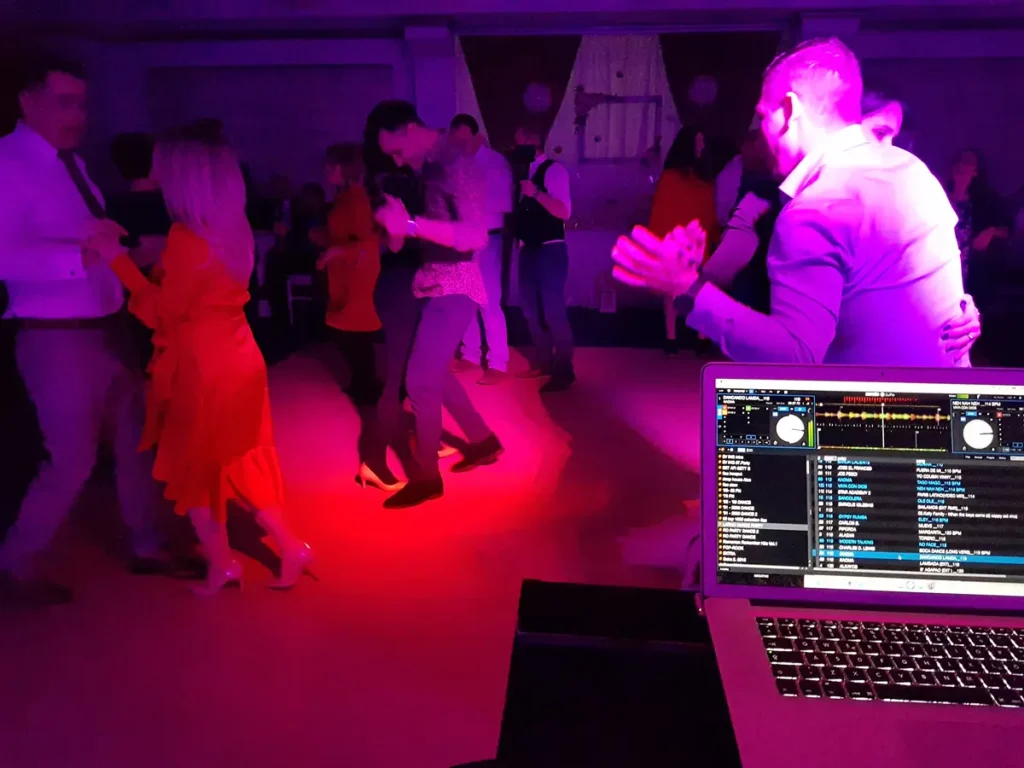 Cupluri dansând, cu consola DJ în prim-plan