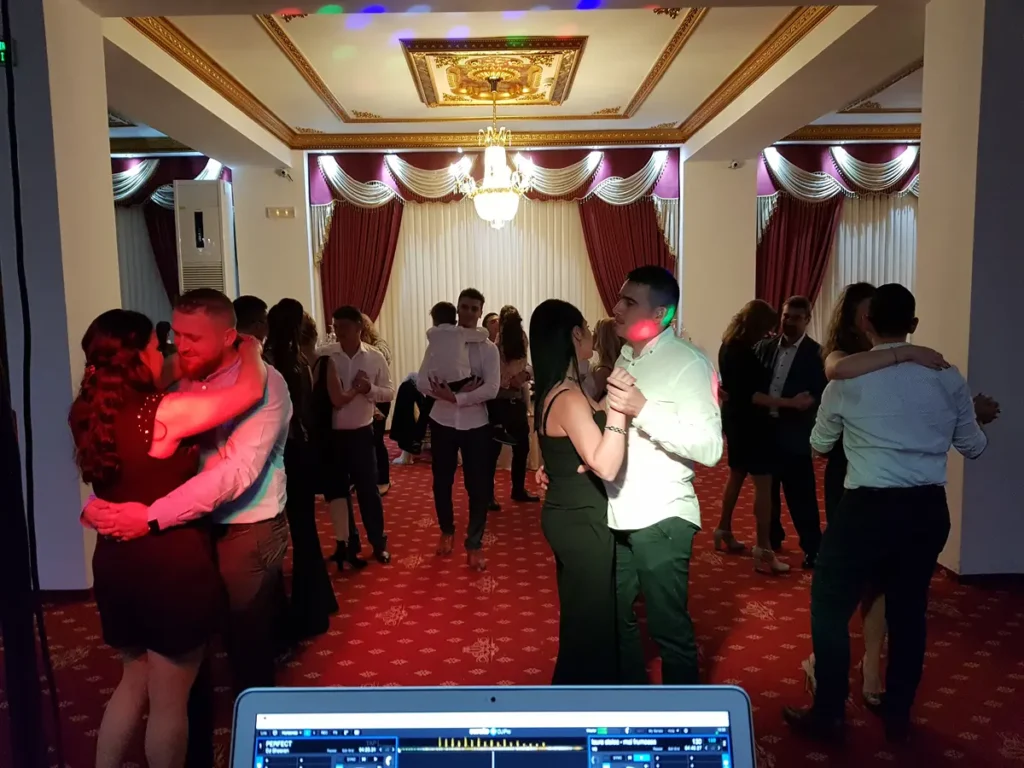 Cupluri la dans într-o sală elegantă cu candelabre