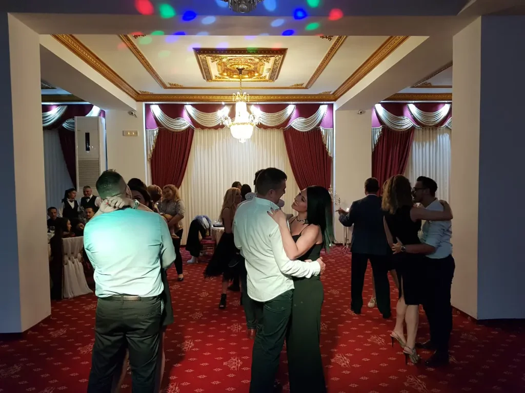 Cupluri la dans într-o sală elegantă cu candelabre
