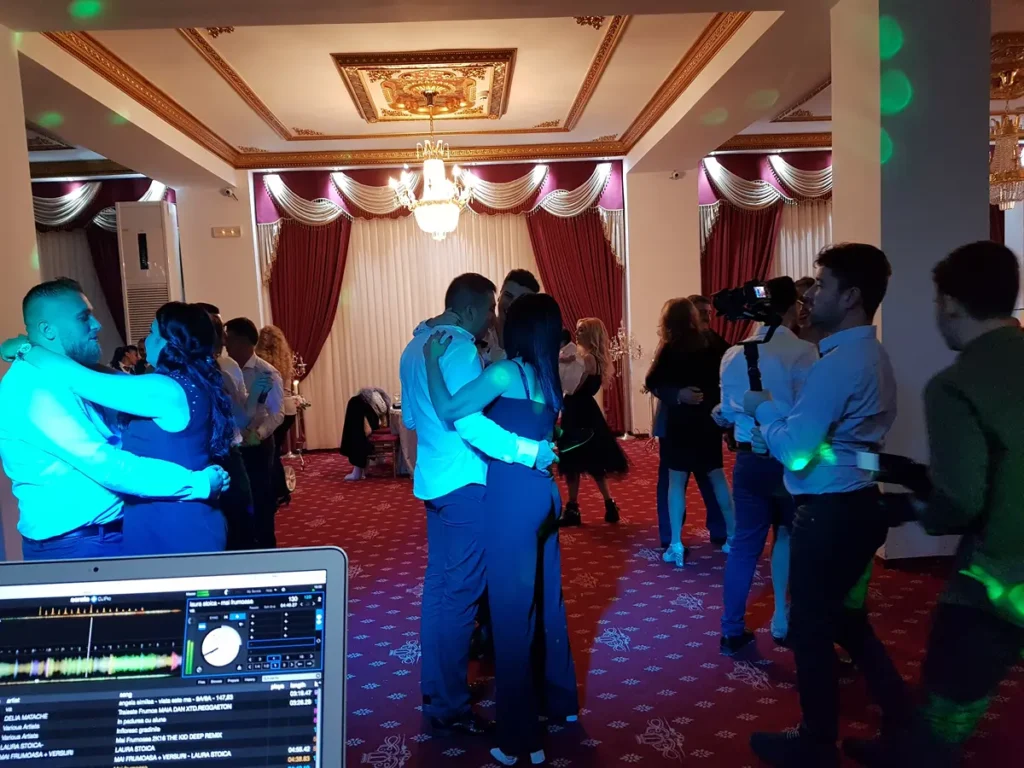 Cupluri la dans într-o sală elegantă cu candelabre