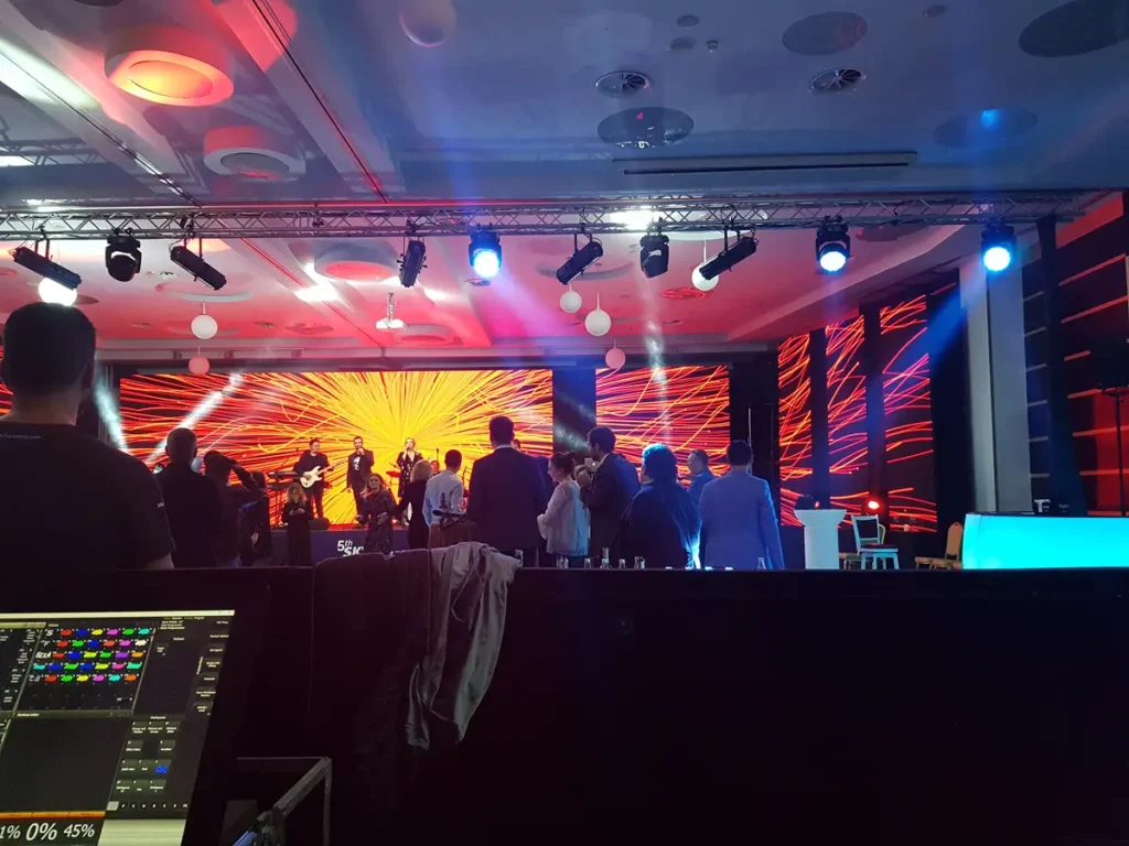 Scenă de eveniment corporate cu instalație LED portocalie