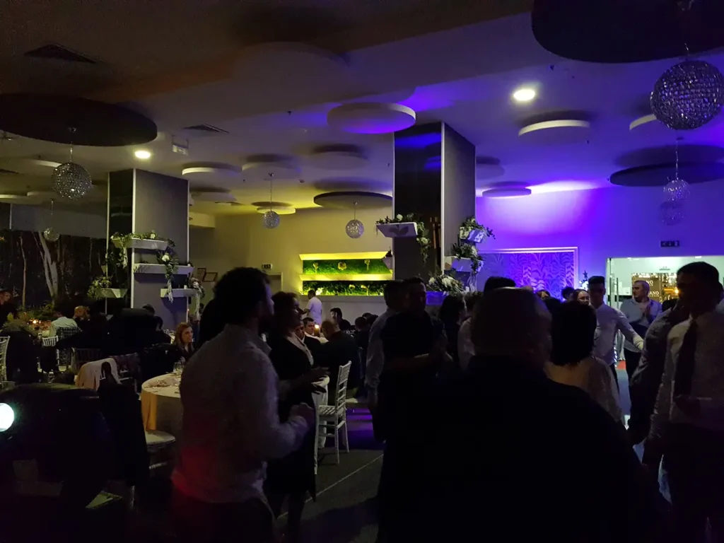 Petrecere într-o sală modernă cu glob disco și lumini albastre